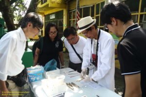 Japanese and Filipino government representatives and forensic experts examining remains of war dead at Bamban WWII Museum, circa 2019.